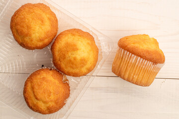 Delicious muffins  on a wooden table, top view, close-up.