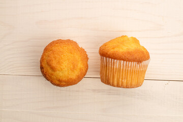 Delicious muffins  on a wooden table, top view, close-up.