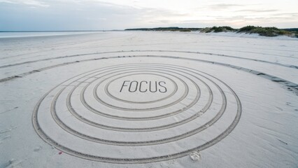 Concentric circles and the word FOCUS drawn on a sandy beach
