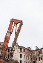 Powerful excavator demolishes old urban building in industrial scene
