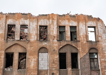 Crumbling facade of abandoned urban building shows layers of decay