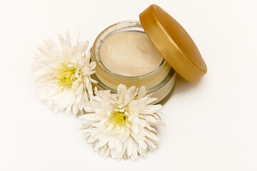 White glass container on white background with white flowers.