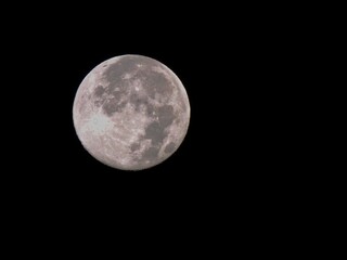 Full moon shines brightly in a clear night sky, illuminating the darkness and creating a serene atmosphere for stargazers to enjoy