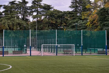 Soccer goal surrounded by fences and trees in a public sports facility during fall time