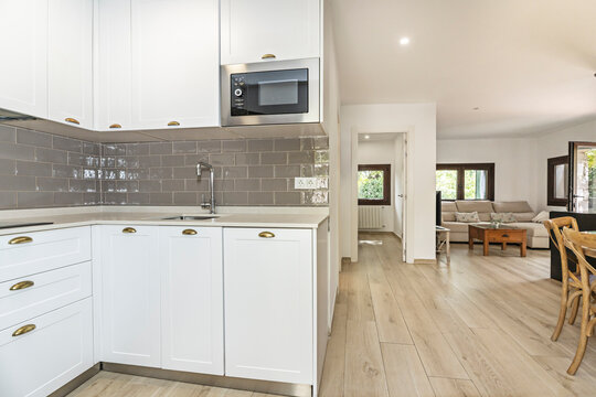 Image of a small kitchen with a U-shaped layout, showcasing space efficiency with a quartz countertop and a high-arm single-lever faucet