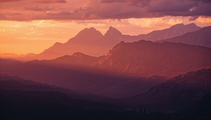 Stunning mountain range silhouette at sunset with vibrant orange and purple hues, perfect for travel and scenic projects
