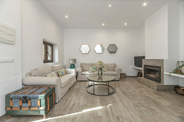 Side view of a living room with two Chesterfield sofas facing a bioethanol fireplace recessed into a drywall panel
