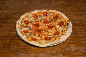 The intense spiciness of the Diavola pizza is revealed in the slices of spicy salami evenly distributed over a layer of melted mozzarella cheese
