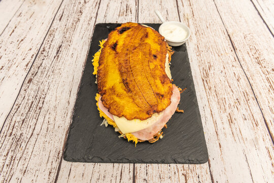 Traditional Venezuelan patacones, flattened and fried twice, topped with strips of queso de mano (a type of Venezuelan cheese) and served with whey
