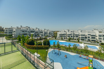 Fototapeta premium Residential pool area with a free-form design and infinity edge, integrated into a palm garden and natural lawn, including walk-in showers and changing rooms.