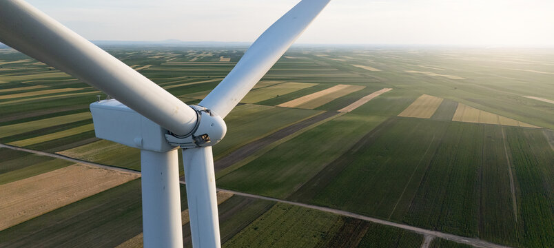 Aerial view of wind turbine on an agricultural filed at sunset. Close up of blades