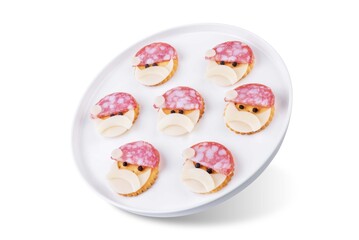 Salami sausage and cheese slices and crackers in the form of Santa Claus for Christmas holidays on a white isolated background
