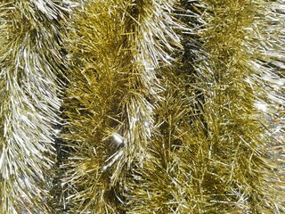 Background of a pile of shiny gold and silver tinsel. Handcrafted of combination gold and silver colored tinsel slinger made of shiny metallic plastic for various festive occasions or events.