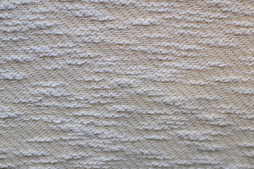 Close up of beige knit fabric texture with soft pattern and warm cozy feel