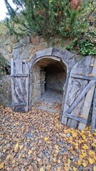 Ancient Stone Archway into Woodland Hidden Passageway Surrounded by Autumn Leaves