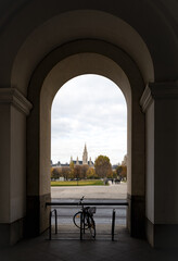 View of the Vienna City Hall from the arcade of the Hofburg across the autumn park