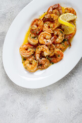 fried tiger prawns, jumbo, in garlic sauce, in butter, with herbs, on a white plate, homemade, no people,