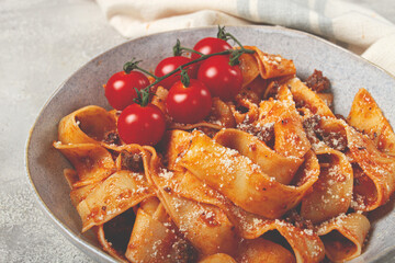 pappardelle pasta with bolognese sauce, topped with parmesan cheese and cherry branch, homemade, no people,