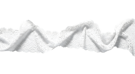 Close up of delicate white lace trim with a ruffled edge against a stark black background