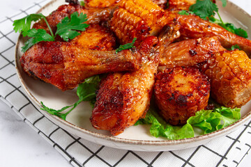 Fried chicken drumsticks, Mexican style, with corn, on a plate, close-up,
