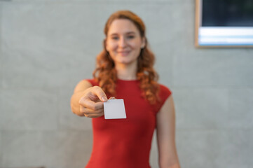 Female receptionist giving key card while standing at counter in hotel lobby. Select focut to key...