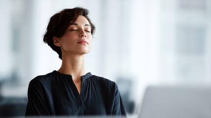 Female office worker practicing mindfulness and meditation at desk, promoting relaxation and work-life balance