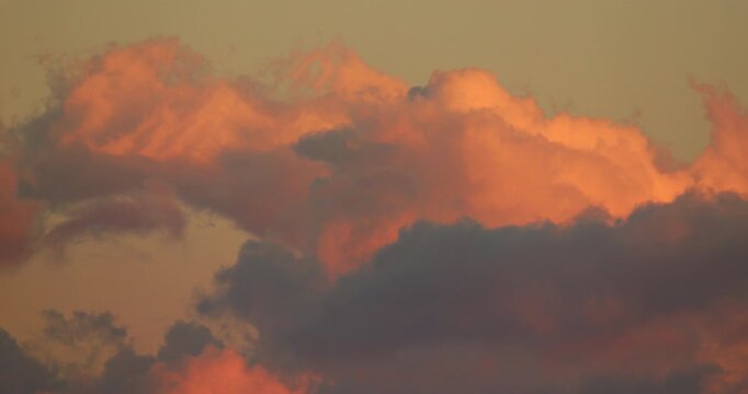 Sunset clouds timelapse, glowing vivid orange and deep red against progressively darkening evening sky background
