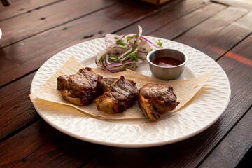 Lamb apple shashlik with fried tomato sauce and lavash on a white plate