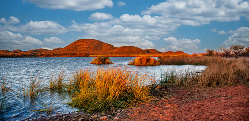 lake, dam at Mokolodi Nature Reserve, shore with reeds, and hill range, located near Gaborone, Botswana