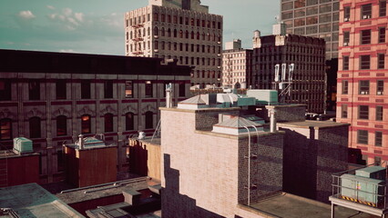 In this bustling city scene, rooftops rise amidst a skyline of historic and modern buildings. Sunlight reflects off surfaces, revealing textures and colors that tell stories of urban life.