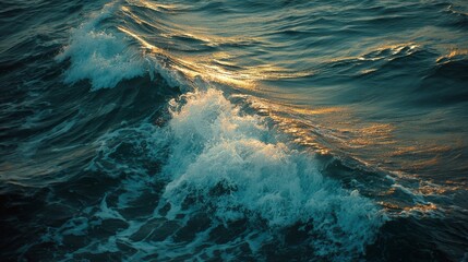Powerful blue ocean waves break with white foam on the rocky coast under a summer sky
