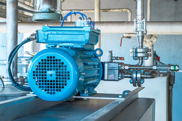 Industrial equipment. Detail of new blue electric motors with pumps on the stainless steel production line. Industrial background. Additive pump station in petrochemical technology. Industrial area.