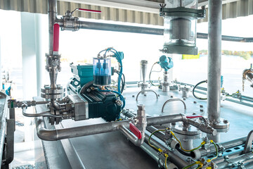 Industrial equipment. Detail of new blue electric motors with pumps on the stainless steel production line. Industrial background. Additive pump station in petrochemical technology. Industrial area.