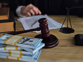 Legal proceedings involving money, a gavel, and documents in a courthouse