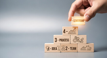 Hand putting wooden block with leadership word on top of wooden blocks stairs
