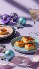 Holiday party appetizers with champagne on a purple background. Vertical still life with savory puff pastries and Christmas ornaments for a New Year celebration