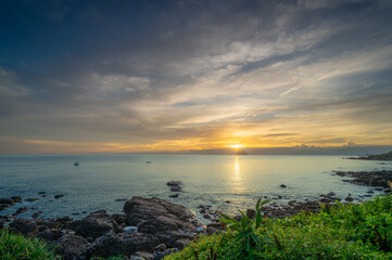 Obraz premium A spectacular summer sunrise over the Waimushan coastline in Keelung, Taiwan. The sky is painted with vibrant colors as the sun rises near the majestic Keelung Islet.