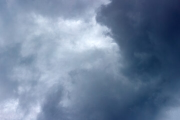 Dark storm clouds fill the sky, creating a dramatic and moody atmosphere. The overcast conditions suggest impending rain, highlighting the beauty of nature's power.