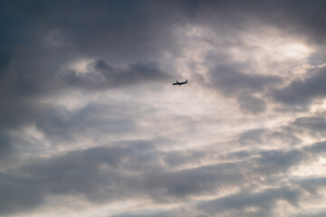 A dramatic video of a passenger airplane flying left under high altitude clouds Filmed in Shimen New Taipei City Taiwan on a beautiful summer afternoon.