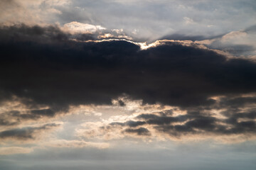 Golden sunlight breaks through clouds at dusk, casting reflections on the sea along Shimen coast in New Taipei Taiwan.