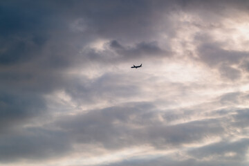 Fototapeta premium A dramatic video of a passenger airplane flying left under high altitude clouds Filmed in Shimen New Taipei City Taiwan on a beautiful summer afternoon.