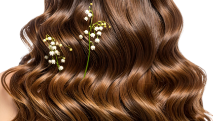 Close-up of styled brown hair with delicate curls and small white flowers tucked in