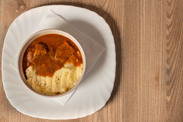 Goulash with beef and carrots with mashed potatoes top view on wooden table