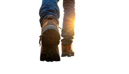 Close-up of legs walking away, sunlight filters between them, boots