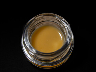 Close up macro cannabis oil concentrate dab on black background