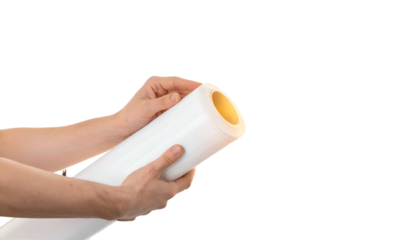 Hands unrolling a white rolled paper item, revealing a yellow core. Isolated
