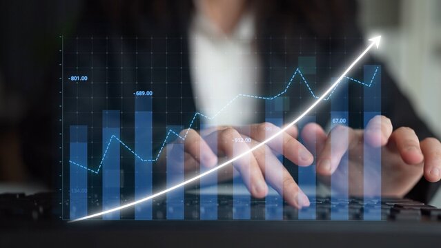 A business professional focuses on analyzing data and trends using digital graphs and charts, highlighting growth and opportunities in a modern office setting. Copula