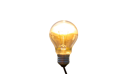 A bright, glowing incandescent lightbulb shines against a stark black background