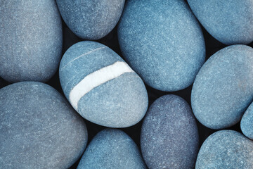 Pebbles stones on seashore as  texture background for design of web banner template page. many stones and they are different in color and size, dry stones illuminated by sun.