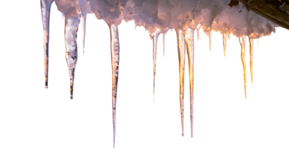 Close-up of icicles hanging from a structure, illuminated with a warm, golden glow